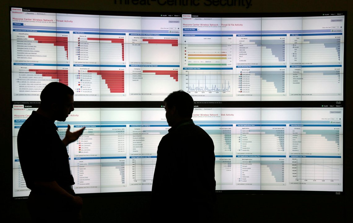 FILE - In this Wednesday, April 22, 2015, file photo, Stijn Vanveerdeghem, left, an engineer with Cisco, shows graphics with live wireless traffic to FedEx employee Barry Poole during the RSA Conference in San Francisco, where threat analysts, security vendors and corporate IT administrators gathered to talk about malicious software, spear-phishing and other attacks that can steal money or secrets from companies and consumers. As the Friday, May 12, 2017, global cyberextortion attack that held peopleÄôs computer files hostage slows, authorities are working to catch the crooks behind it, which is a difficult task that involves searching for digital clues and following the money. (AP Photo/Marcio Jose Sanchez, File) FILE - In this Wednesday, April 22, 2015, file photo, Stijn Vanveerdeghem, left, an engineer with Cisco, shows graphics with live wireless traffic to FedEx employee Barry Poole during the RSA Conference in San Francisco, where threat analysts, security vendors and corporate IT administrators gathered to talk about malicious software, spear-phishing and other attacks that can steal money or secrets from companies and consumers. As the Friday, May 12, 2017, global cyberextortion attack that held peopleÄôs computer files hostage slows, authorities are working to catch the crooks behind it, which is a difficult task that involves searching for digital clues and following the money. (AP Photo/Marcio Jose Sanchez, File)