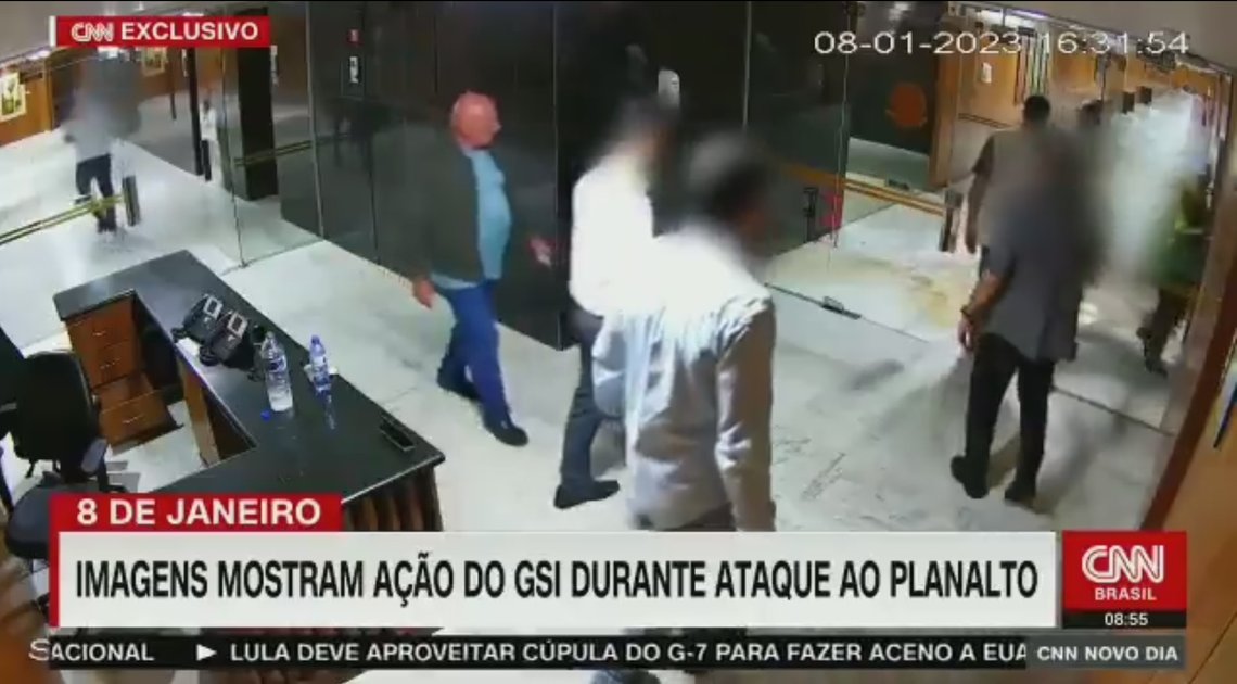 General Marcos Gonçalves Dias i mørk grønn jakke, går rolig gjennom palasset mens vandalene herjer. Skjermdump fra Twitter General Marcos Gonçalves Dias i mørk grønn jakke, går rolig gjennom palasset mens vandalene herjer. Skjermdump fra Twitter