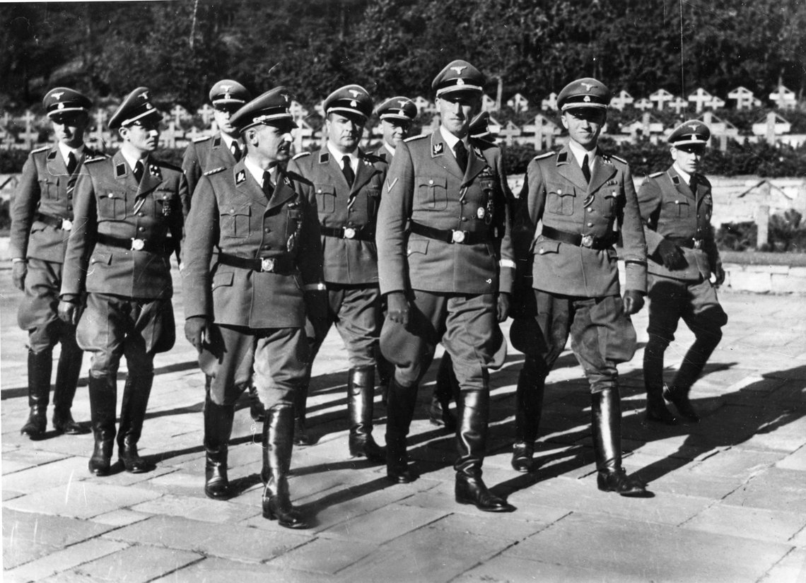SS Gruppenführer Reinhard Heydrich (midt i første rekke), på besøk i Norge den tyske okkupasjonen av Norge under annen verdenskrig. Heinrich Fehlis, sjefen for tysk sikkerhetspoliti og sikkerhetstjeneste ( Gestapo) i Oslo under krigen (t.h.). Rolf Schiedermair (til venstre, litt bak Heydrich). Redaktøren i Utrop trekker sammenligning med det disse gjorde overfor jøder i Norge, med hva byrådet i Oslo gjør overfor ikke-hvite asylsøkere.
Foto: NTB SS Gruppenführer Reinhard Heydrich (midt i første rekke), på besøk i Norge den tyske okkupasjonen av Norge under annen verdenskrig. Heinrich Fehlis, sjefen for tysk sikkerhetspoliti og sikkerhetstjeneste ( Gestapo) i Oslo under krigen (t.h.). Rolf Schiedermair (til venstre, litt bak Heydrich). Redaktøren i Utrop trekker sammenligning med det disse gjorde overfor jøder i Norge, med hva byrådet i Oslo gjør overfor ikke-hvite asylsøkere.
Foto: NTB