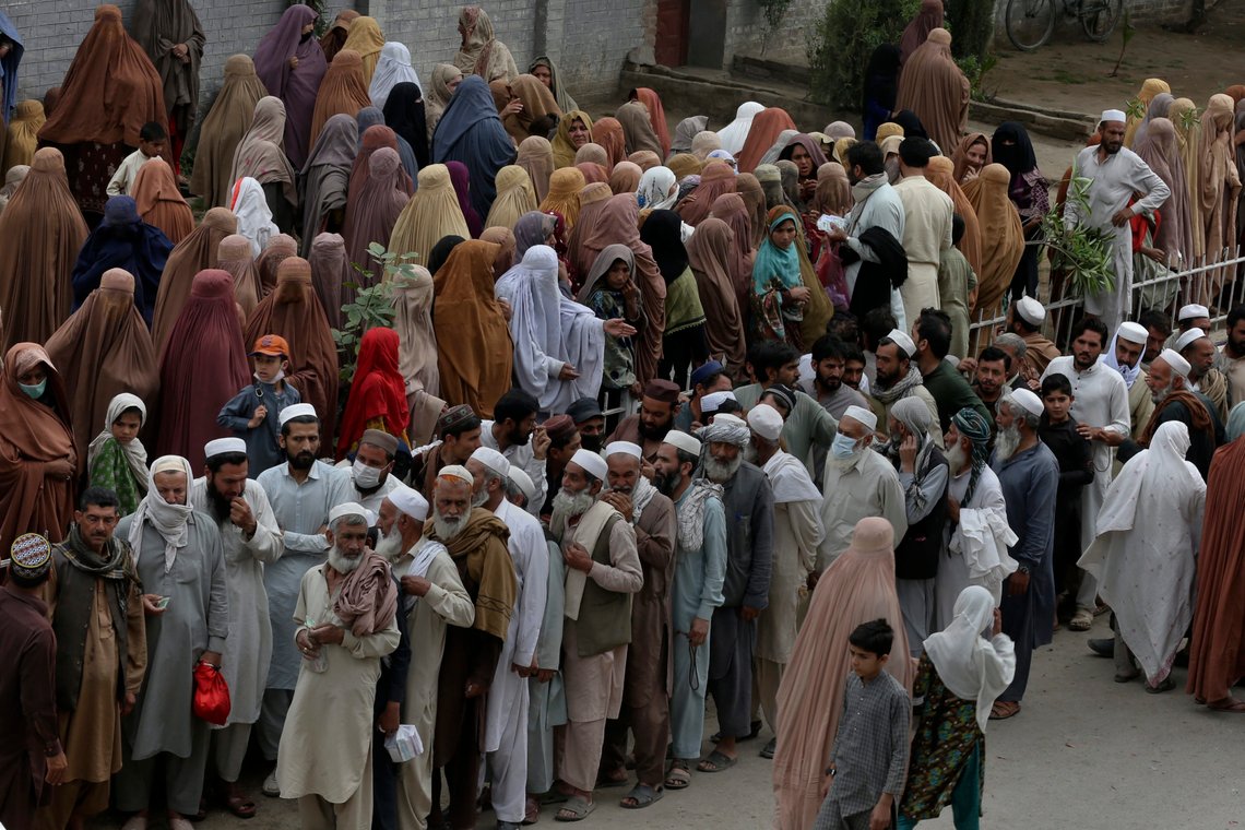 People gather and wait their turn to get a free sack of wheat flour at a distribution point, in Peshawar, Pakistan, Wednesday, March 29, 2023. Pakistan's government is providing free wheat-flour to deserving and poor families during the Muslim's holy month of Ramadan due to high inflation in the country. (AP Photo/Muhammad Sajjad) People gather and wait their turn to get a free sack of wheat flour at a distribution point, in Peshawar, Pakistan, Wednesday, March 29, 2023. Pakistan's government is providing free wheat-flour to deserving and poor families during the Muslim's holy month of Ramadan due to high inflation in the country. (AP Photo/Muhammad Sajjad)