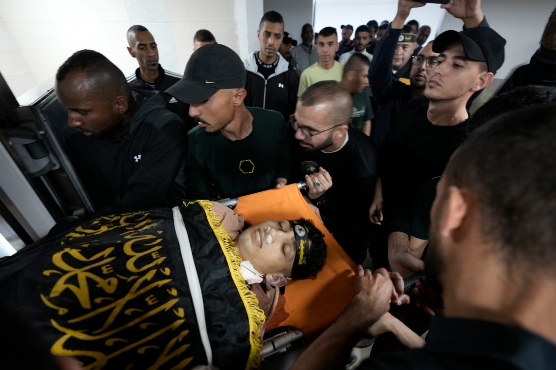 Relatives take a last look at Ahmed Assaf, 19, draped in the flag of Islamic Jihad, one of two Palestinians killed by Israeli forces in Qabatiya, near the West Bank city of Jenin, Wednesday, May 10, 2023. The Israeli military said that Palestinian gunmen opened fire at troops in the Palestinian town of Qabatiya in the northern West Bank during an army raid. Troops returned fire, killing the two men, and confiscated their firearms, it said. (AP Photo/Majdi Mohammed) Relatives take a last look at Ahmed Assaf, 19, draped in the flag of Islamic Jihad, one of two Palestinians killed by Israeli forces in Qabatiya, near the West Bank city of Jenin, Wednesday, May 10, 2023. The Israeli military said that Palestinian gunmen opened fire at troops in the Palestinian town of Qabatiya in the northern West Bank during an army raid. Troops returned fire, killing the two men, and confiscated their firearms, it said. (AP Photo/Majdi Mohammed)