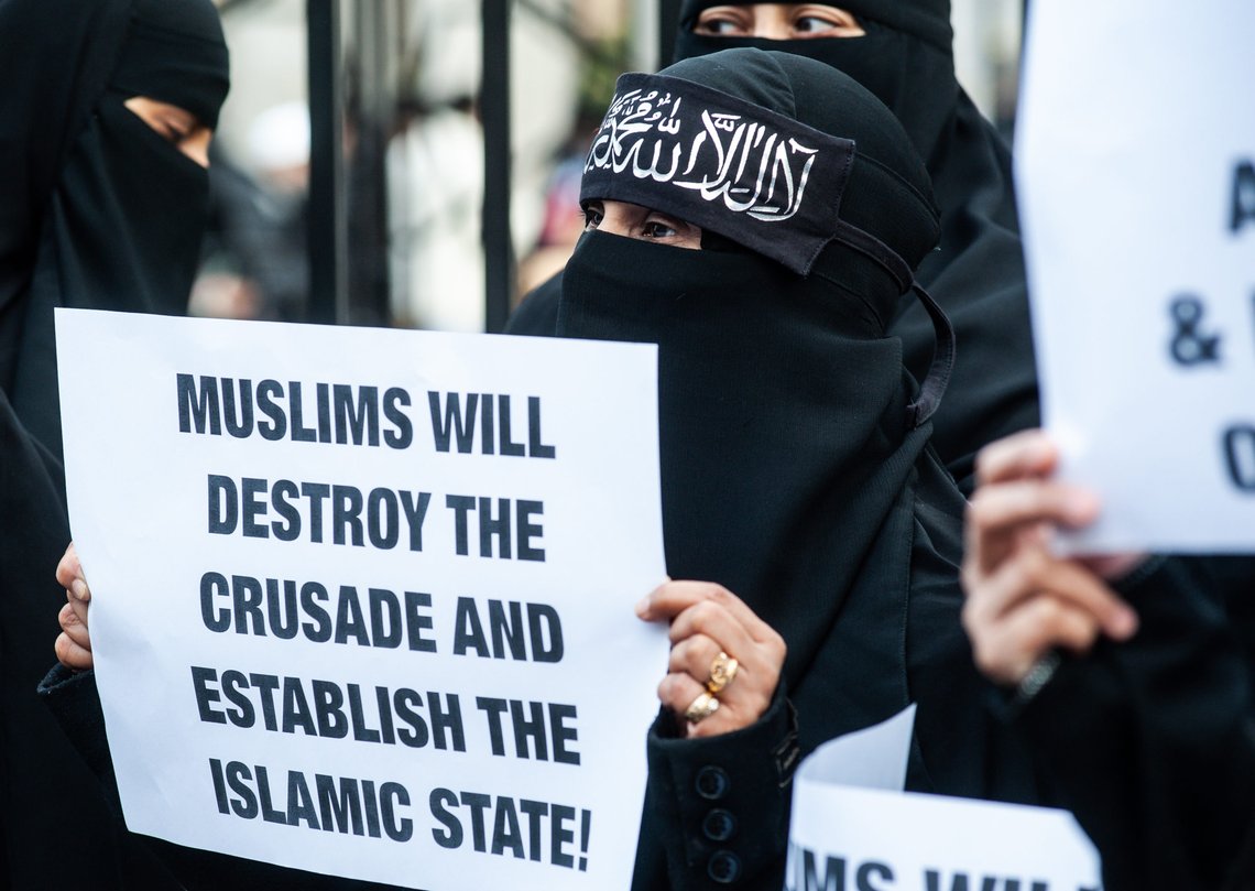 London, UK - 24 January 2014: a woman holds a placard reading "Muslims will destroy the crusade and estabilish the Islamic State!" outside the Regents Park Mosque. Photo: Shutterstock, pcruciatti, Italy. London, UK - 24 January 2014: a woman holds a placard reading "Muslims will destroy the crusade and estabilish the Islamic State!" outside the Regents Park Mosque. Photo: Shutterstock, pcruciatti, Italy.