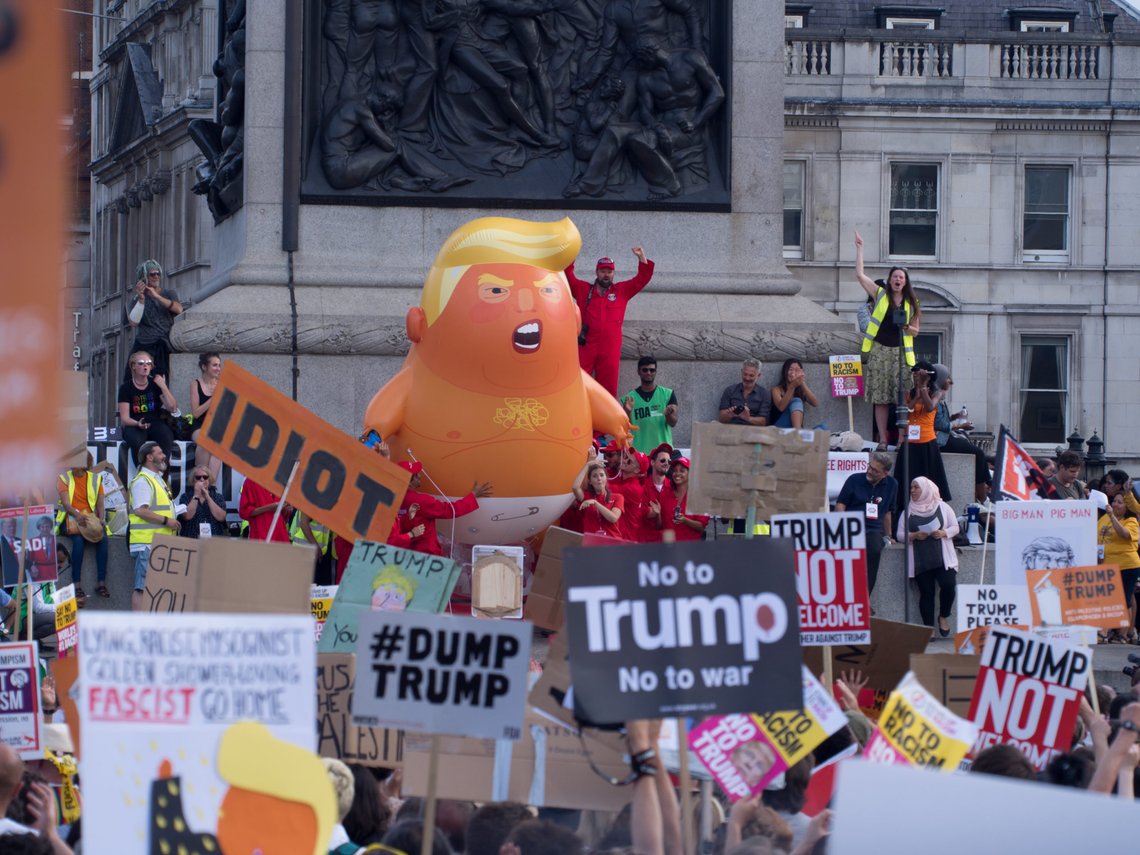 London, United Kingdom - July 13, 2018: Orange Baby Trump balloon at Trafalgar Square next to Nelson's Column during the grand finale of the anti-Trump protest. Photo: Shutterstock, Mia Elliott Smith, United Kingdom. London, United Kingdom - July 13, 2018: Orange Baby Trump balloon at Trafalgar Square next to Nelson's Column during the grand finale of the anti-Trump protest. Photo: Shutterstock, Mia Elliott Smith, United Kingdom.