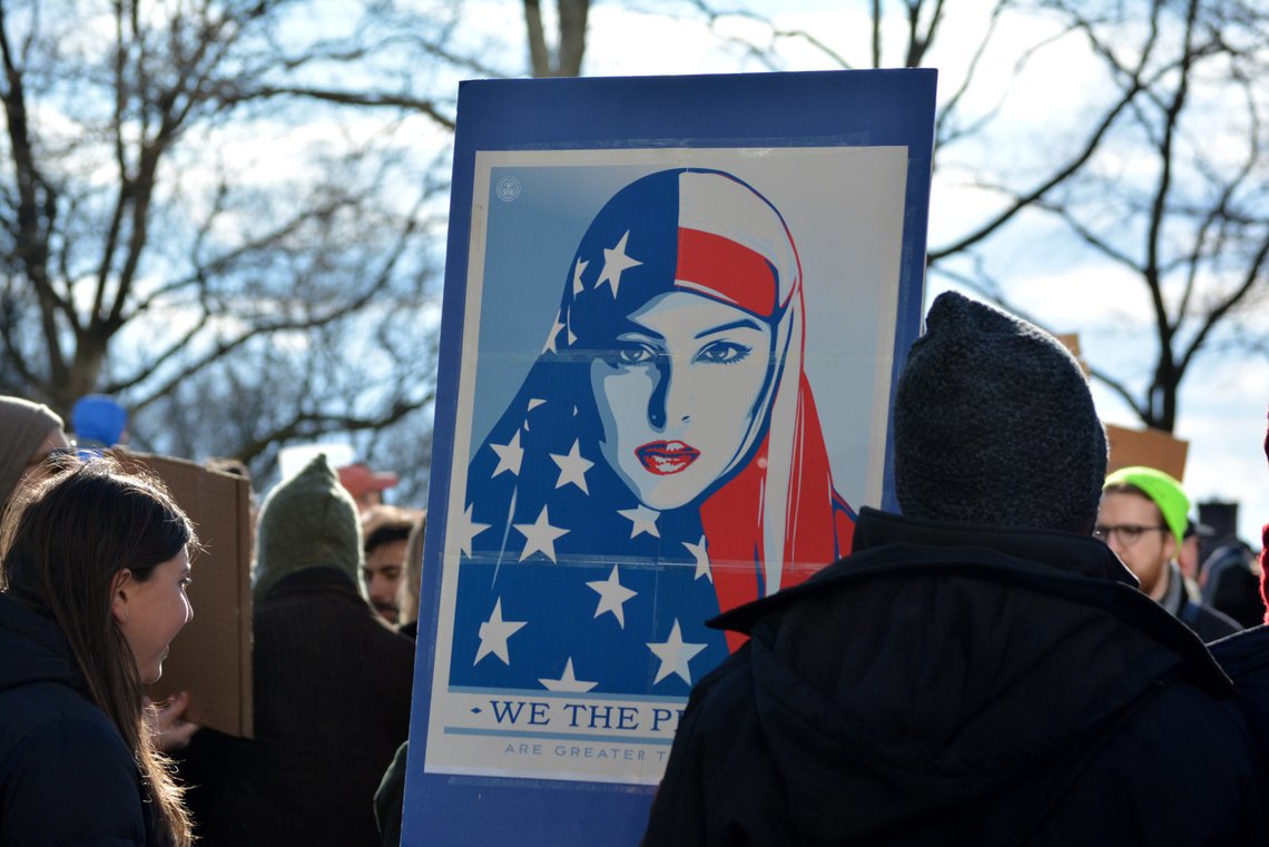 New York, New York. - January 29, 2017: People protesting the new immigration laws banning some Muslims at Battery Park in Manhattan in 2017 in New York City. Photo: Shutterstock by Christopher Penler. New York, New York. - January 29, 2017: People protesting the new immigration laws banning some Muslims at Battery Park in Manhattan in 2017 in New York City. Photo: Shutterstock by Christopher Penler.