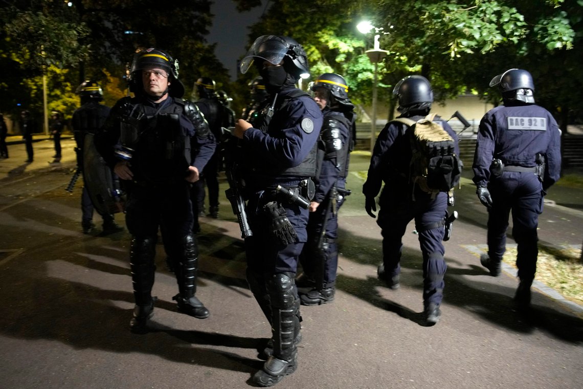 A group of police officers walk during a protest in Nanterre, outside Paris, France, Saturday, July 1, 2023. French President Emmanuel Macron urged parents Friday to keep teenagers at home and proposed restrictions on social media to quell rioting spreading across France over the fatal police shooting of a 17-year-old driver. (AP Photo/Lewis Joly) A group of police officers walk during a protest in Nanterre, outside Paris, France, Saturday, July 1, 2023. French President Emmanuel Macron urged parents Friday to keep teenagers at home and proposed restrictions on social media to quell rioting spreading across France over the fatal police shooting of a 17-year-old driver. (AP Photo/Lewis Joly)