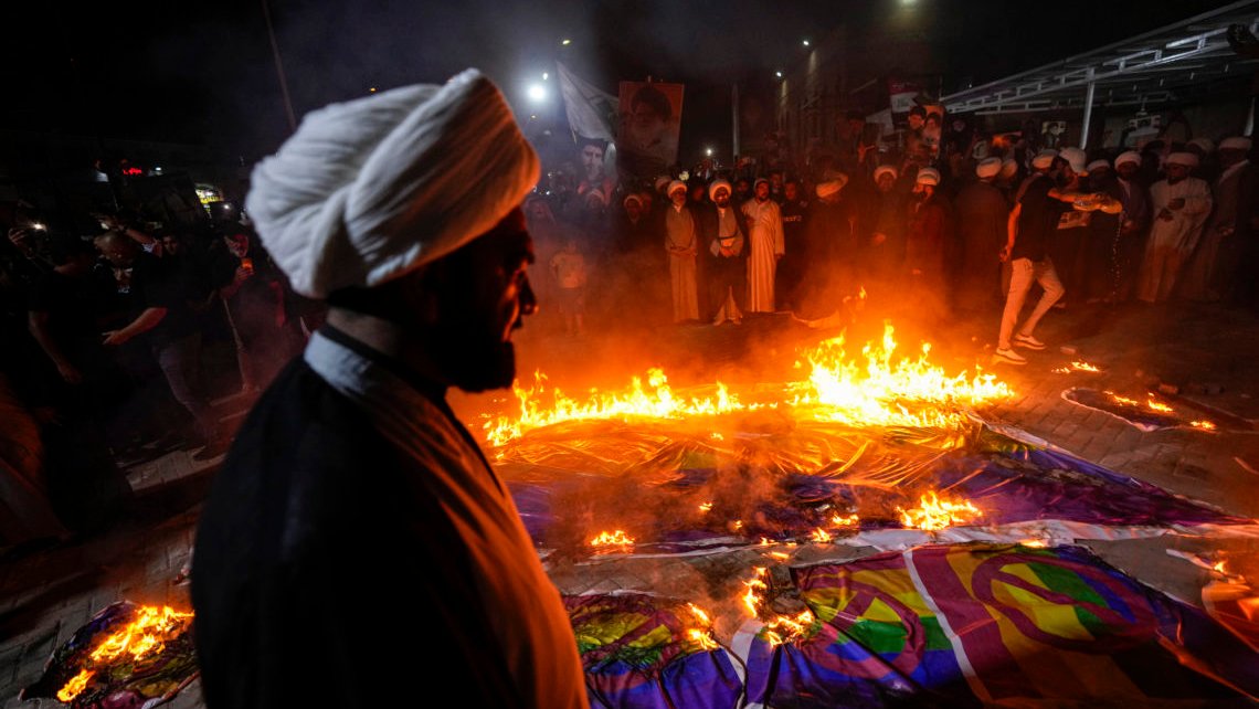 For å protestere mot koranbrenning i Sverige, brenner Moqtadah al-Sadrs tilhengere "regnbueflagg", skriver AP. De vil ikke si Prideflagg, det blir for politisk ubekvemt. Men det er hva det er. Supporters of Shiite Muslim leader Moqtada Sadr burn rainbow flags, during a demonstration in Sadr City, in response to the burning of Quran in Sweden, Baghdad, Iraq, Wednesday, July 12, 2023. (AP Photo/Hadi Mizban) For å protestere mot koranbrenning i Sverige, brenner Moqtadah al-Sadrs tilhengere "regnbueflagg", skriver AP. De vil ikke si Prideflagg, det blir for politisk ubekvemt. Men det er hva det er. Supporters of Shiite Muslim leader Moqtada Sadr burn rainbow flags, during a demonstration in Sadr City, in response to the burning of Quran in Sweden, Baghdad, Iraq, Wednesday, July 12, 2023. (AP Photo/Hadi Mizban)