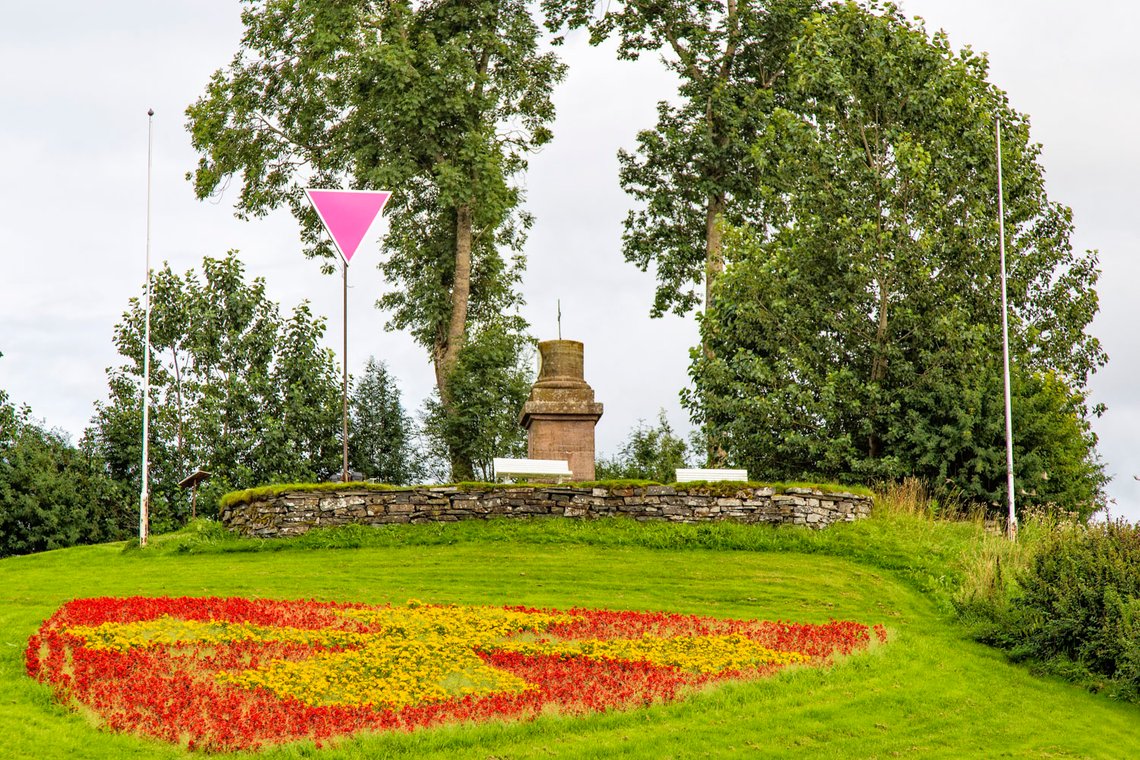 Olavshaugen på Stiklestad ble preget av pride-symbol sommeren 2022, og ikke bare ved olsok. Her flagges det for Pride, mens flaggstengene er nakne, i august 2022. Blomsterdekorasjonen ved Olavsstøtta er preget med Olavskorset. Under olsokfeiringen i 2023 skal det samiske flagget vaie sammen med det norske. Foto: Bente Haarstad. Olavshaugen på Stiklestad ble preget av pride-symbol sommeren 2022, og ikke bare ved olsok. Her flagges det for Pride, mens flaggstengene er nakne, i august 2022. Blomsterdekorasjonen ved Olavsstøtta er preget med Olavskorset. Under olsokfeiringen i 2023 skal det samiske flagget vaie sammen med det norske. Foto: Bente Haarstad.