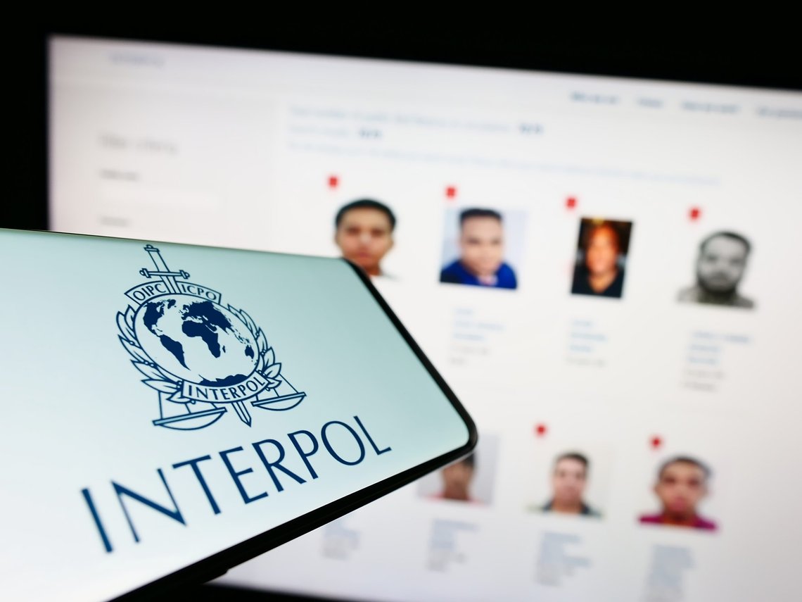 Stuttgart, Germany - 01-22-2023: Mobile phone with logo of International Criminal Police Organization (ICPO) on screen in front of website. Photo: Shutterstock by T. Schneider, Germany. Stuttgart, Germany - 01-22-2023: Mobile phone with logo of International Criminal Police Organization (ICPO) on screen in front of website. Photo: Shutterstock by T. Schneider, Germany.