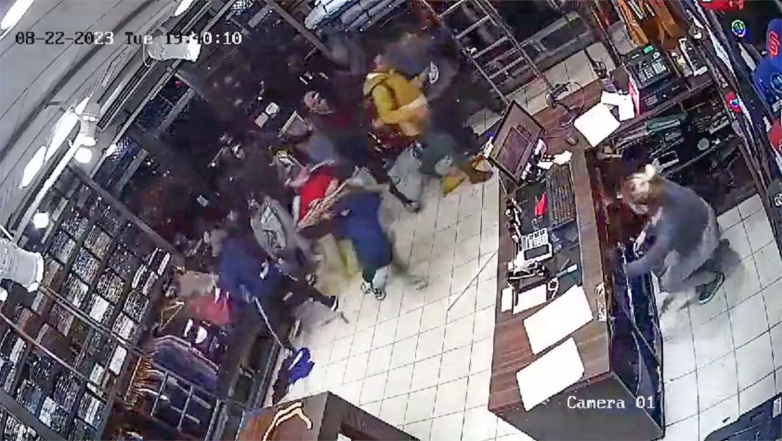 En skremt ansatt gjemmer seg bak skranken mens butikken plyndres. Videoklipp fra Twitter En skremt ansatt gjemmer seg bak skranken mens butikken plyndres. Videoklipp fra Twitter