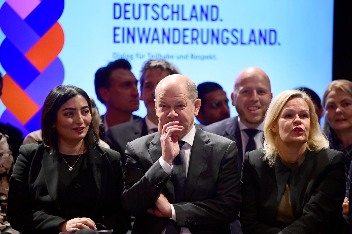 German Chancellor Olaf Scholz is flanked by Federal Government's Commissioner for Migration, Refugees and Integration Reem Alabali-Radovan, left, and German Interior Minister Nancy Faeser, right, during an immigration meeting "Germany, Immigration Country, Dialogue for Participation and Respect" in Berlin, Monday, Nov. 28, 2022. Writing in the background reads "Germany. Immigration land." (John MacDougall/Pool Photo via AP) German Chancellor Olaf Scholz is flanked by Federal Government's Commissioner for Migration, Refugees and Integration Reem Alabali-Radovan, left, and German Interior Minister Nancy Faeser, right, during an immigration meeting "Germany, Immigration Country, Dialogue for Participation and Respect" in Berlin, Monday, Nov. 28, 2022. Writing in the background reads "Germany. Immigration land." (John MacDougall/Pool Photo via AP)