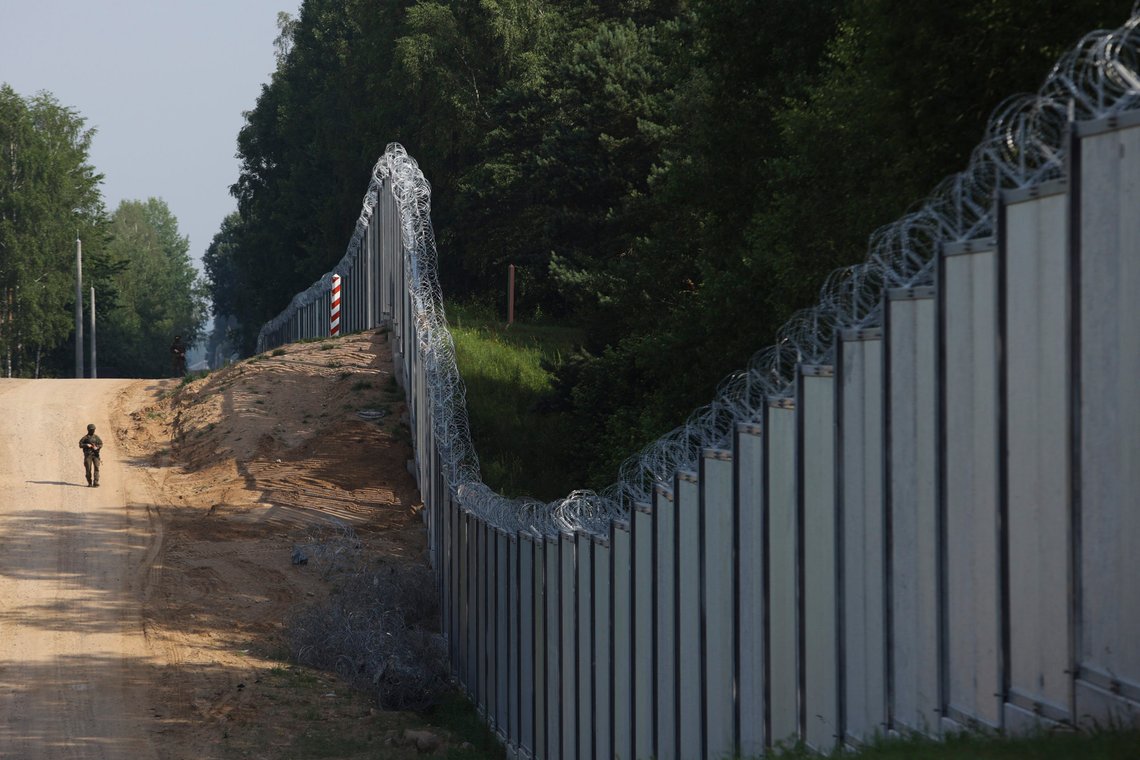 FILE - A Polish border guard patrols the area of a built metal wall on the border between Poland and Belarus, near Kuznice, Poland, on June 30, 2022. Poland is deploying thousands of troops to its border with pro-Russian Belarus, calling it a deterrent move as tensions between the neighbors ratchet up. Officials in Belarus have been making hostile comments about Poland, a European Union and NATO member. (AP Photo/Michal Dyjuk, File) FILE - A Polish border guard patrols the area of a built metal wall on the border between Poland and Belarus, near Kuznice, Poland, on June 30, 2022. Poland is deploying thousands of troops to its border with pro-Russian Belarus, calling it a deterrent move as tensions between the neighbors ratchet up. Officials in Belarus have been making hostile comments about Poland, a European Union and NATO member. (AP Photo/Michal Dyjuk, File)