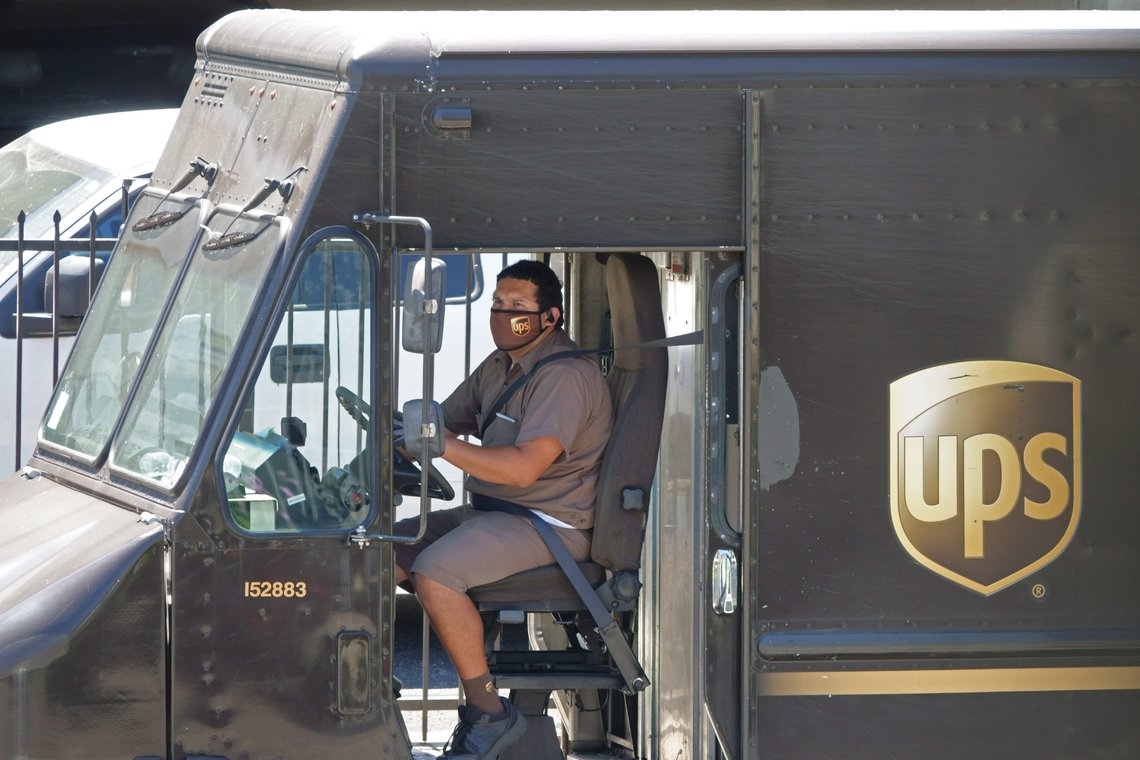 Los Angeles, CA / USA - April 24, 2020: A United Parcel Service UPS driver wears a company logo mask while parking a delivery truck during the COVID-19 coronavirus pandemic. Photo: Shutterstock by Kilmer Media. Los Angeles, CA / USA - April 24, 2020: A United Parcel Service UPS driver wears a company logo mask while parking a delivery truck during the COVID-19 coronavirus pandemic. Photo: Shutterstock by Kilmer Media.
