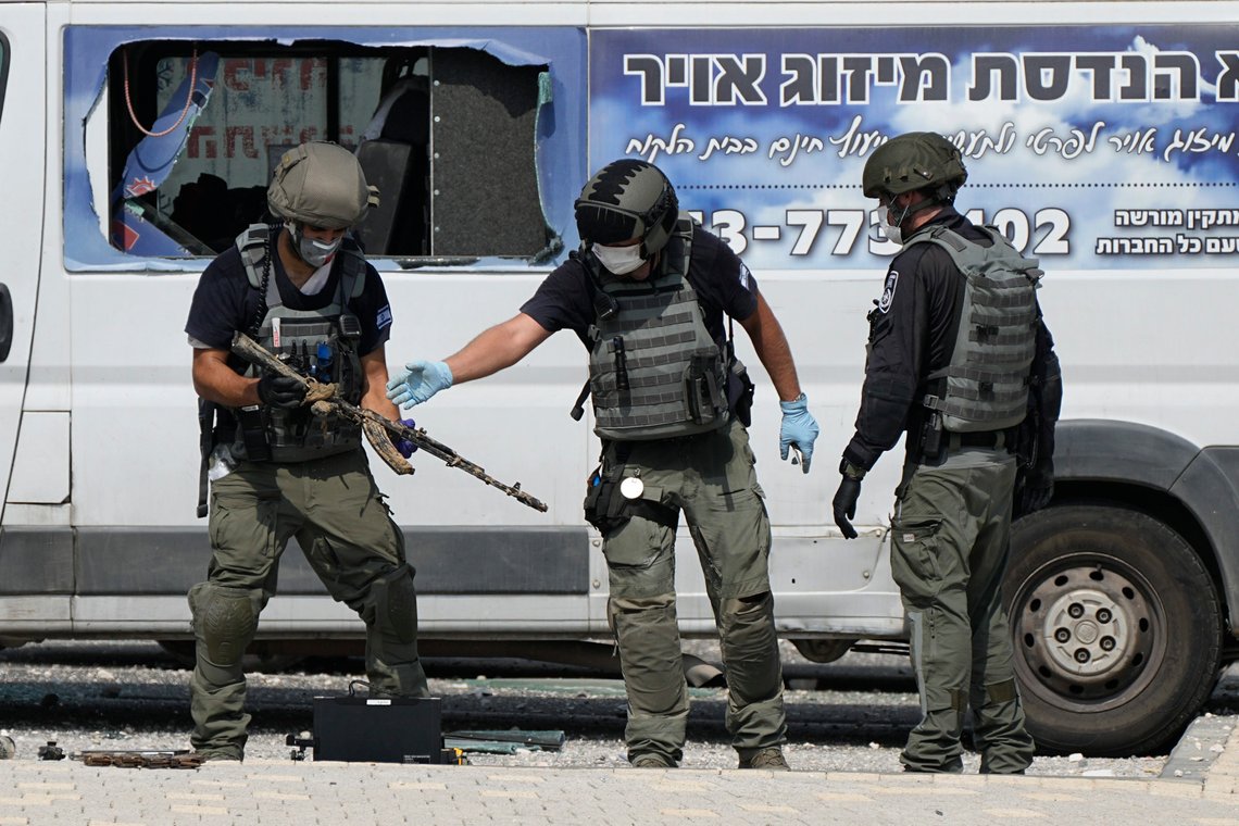 Israeli police retrieve weapons used by militants outside a police station that was overrun by Hamas gunmen on Saturday, in Sderot, Israel, Sunday, Oct.8, 2023. Hamas militants stormed over the border fence Saturday, killing hundreds of Israelis in surrounding communities. (AP Photo/Ohad Zwigenberg) Israeli police retrieve weapons used by militants outside a police station that was overrun by Hamas gunmen on Saturday, in Sderot, Israel, Sunday, Oct.8, 2023. Hamas militants stormed over the border fence Saturday, killing hundreds of Israelis in surrounding communities. (AP Photo/Ohad Zwigenberg)