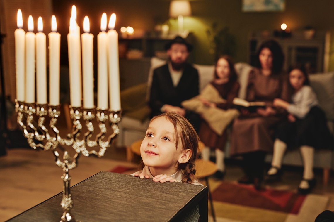 Portrait of jewish little girl looking at menorah candle in awe while. Photo: Shutterstock by SeventyFour, Armenia. Portrait of jewish little girl looking at menorah candle in awe while. Photo: Shutterstock by SeventyFour, Armenia.