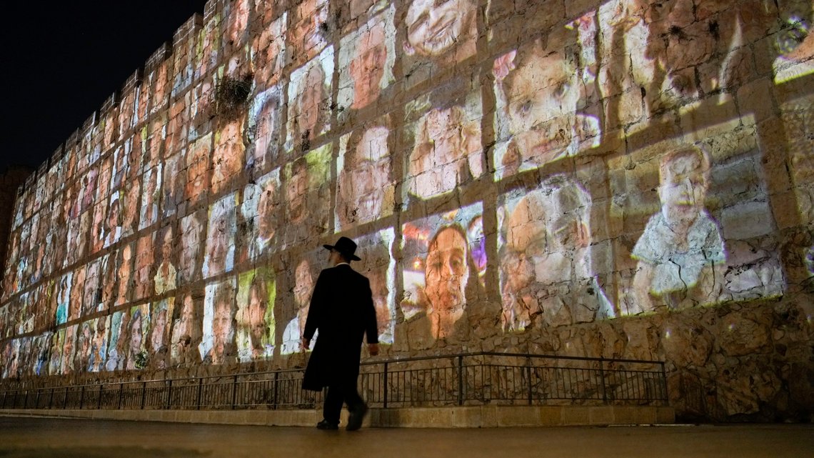 Man får en ide om hvor mye gisselsituasjonen ruver i israelernes sinn når man ser at hele Vestmuren eller Klagemuren, er dekket av gislenes ansikter. Photographs of Israeli hostages being held by Hamas militants are projected on the walls of Jerusalem's Old City, Monday, Nov. 6, 2023. The Islamic militant group killed 1,400 people and kidnapped 240 others in an unprecedented cross-border attack on Oct. 7, triggering a war that has raged for the past month. (AP Photo/Leo Correa) Man får en ide om hvor mye gisselsituasjonen ruver i israelernes sinn når man ser at hele Vestmuren eller Klagemuren, er dekket av gislenes ansikter. Photographs of Israeli hostages being held by Hamas militants are projected on the walls of Jerusalem's Old City, Monday, Nov. 6, 2023. The Islamic militant group killed 1,400 people and kidnapped 240 others in an unprecedented cross-border attack on Oct. 7, triggering a war that has raged for the past month. (AP Photo/Leo Correa)