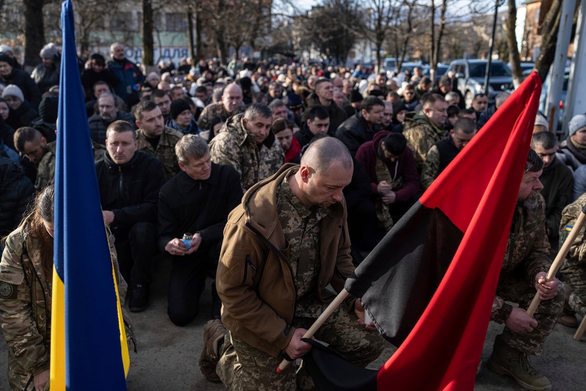 Ukrainian servicemen kneel during the funeral ceremony of their killed comrades Vasyl Medviychuk and Dmytro Dosiak in Verkhovyna, Ukraine, Thursday, Dec. 28, 2023. (AP Photo/Evgeniy Maloletka) Ukrainian servicemen kneel during the funeral ceremony of their killed comrades Vasyl Medviychuk and Dmytro Dosiak in Verkhovyna, Ukraine, Thursday, Dec. 28, 2023. (AP Photo/Evgeniy Maloletka)