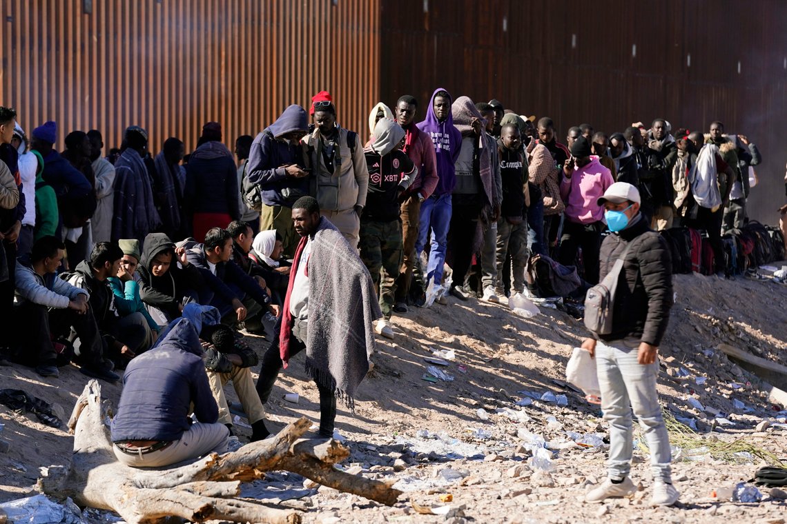 Hundreds of migrants gather along the border after breaking through gaps in the border wall Tuesday, Dec. 5, 2023, in Lukeville, Ariz. The U.S. Border Patrol says it is overwhelmed by a shift in human smuggling routes, with hundreds of migrants from faraway countries like Senegal, Bangladesh and China being dropped in the remote desert area in Arizona. (AP Photo/Ross D. Franklin) Hundreds of migrants gather along the border after breaking through gaps in the border wall Tuesday, Dec. 5, 2023, in Lukeville, Ariz. The U.S. Border Patrol says it is overwhelmed by a shift in human smuggling routes, with hundreds of migrants from faraway countries like Senegal, Bangladesh and China being dropped in the remote desert area in Arizona. (AP Photo/Ross D. Franklin)