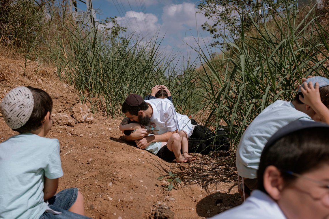 Israelis take cover as a siren sounds a warning of incoming rockets fired from the Gaza Strip in Rehovot, Israel, on Oct. 13, 2023. (AP Photo/Dor Kedmi) Israelis take cover as a siren sounds a warning of incoming rockets fired from the Gaza Strip in Rehovot, Israel, on Oct. 13, 2023. (AP Photo/Dor Kedmi)