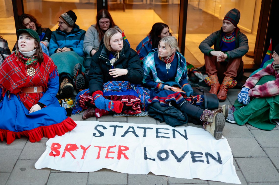 Oslo 20230301.
Aksjonister fra Natur og ungdom og Norske Samers Riksforbund Nuorat utenfor inngangen til Klima- og miljødepartementet. Aklsjonistene demonstrerer i protest mot at vindturbinene på Fosen, som Høyesterett har sagt at er ulovlige, ikke er revet.
Foto: Alf Simensen / NTB Oslo 20230301.
Aksjonister fra Natur og ungdom og Norske Samers Riksforbund Nuorat utenfor inngangen til Klima- og miljødepartementet. Aklsjonistene demonstrerer i protest mot at vindturbinene på Fosen, som Høyesterett har sagt at er ulovlige, ikke er revet.
Foto: Alf Simensen / NTB