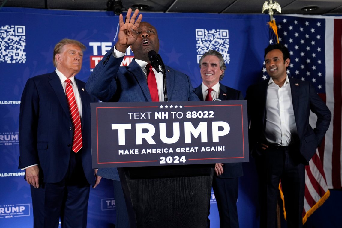 Republican presidential candidate former President Donald Trump listens as former Republican presidential candidates, Sen. Tim Scott, R-S.C., North Dakota Gov. Doug Burgum and Vivek Ramaswamy, appear on stage during a campaign event in Laconia, N.H., Monday, Jan. 22, 2024. (AP Photo/Matt Rourke) Republican presidential candidate former President Donald Trump listens as former Republican presidential candidates, Sen. Tim Scott, R-S.C., North Dakota Gov. Doug Burgum and Vivek Ramaswamy, appear on stage during a campaign event in Laconia, N.H., Monday, Jan. 22, 2024. (AP Photo/Matt Rourke)