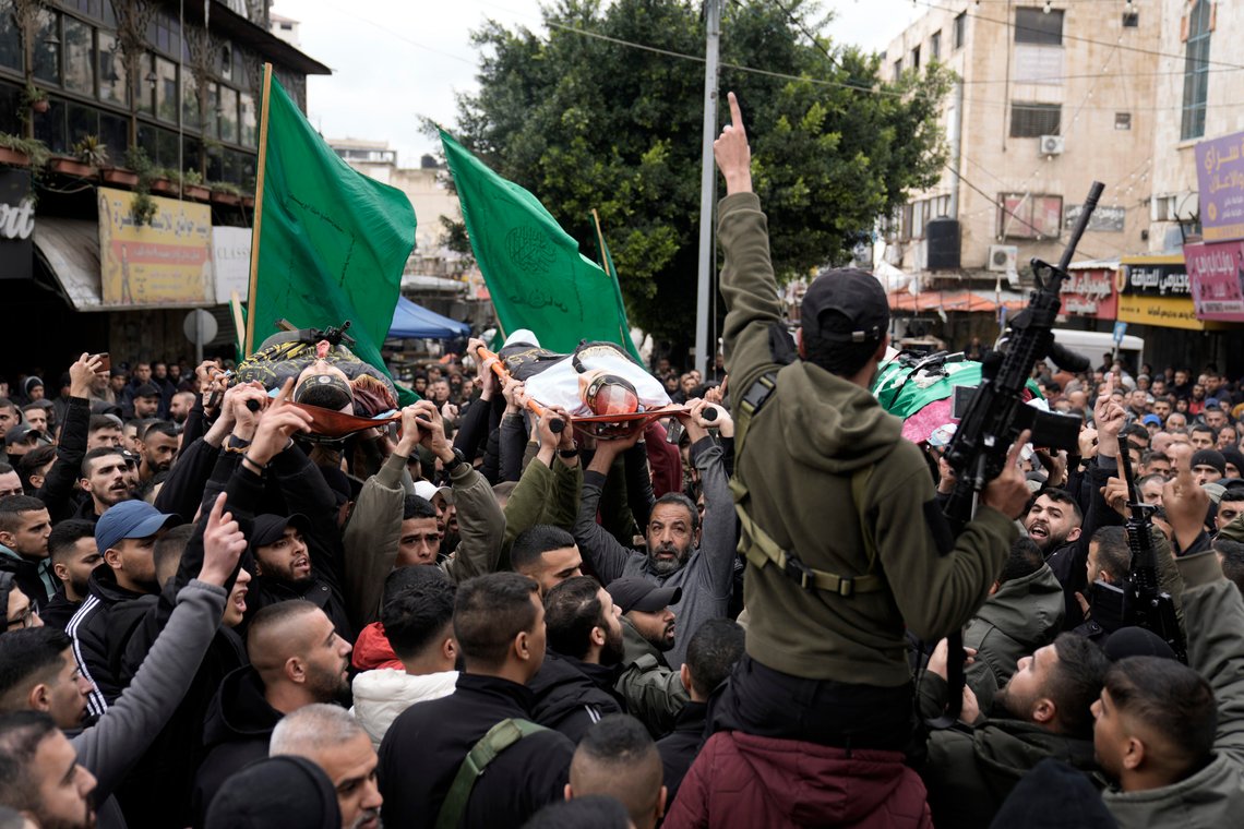 Palestinian gunmen march with bodies of militants draped in the flags of Palestinian Islamic Jihad, killed in an Israeli military raid at Ibn Sina Hospital in the West Bank town of Jenin, Tuesday, Jan. 30, 2024. Armed Israeli undercover forces disguised as women and medical workers stormed the hospital on Tuesday, killing three Palestinian militants. The Palestinian Health Ministry condemned the incursion on a hospital, where the military said the militants were hiding out. (AP Photo/Majdi Mohammed) Palestinian gunmen march with bodies of militants draped in the flags of Palestinian Islamic Jihad, killed in an Israeli military raid at Ibn Sina Hospital in the West Bank town of Jenin, Tuesday, Jan. 30, 2024. Armed Israeli undercover forces disguised as women and medical workers stormed the hospital on Tuesday, killing three Palestinian militants. The Palestinian Health Ministry condemned the incursion on a hospital, where the military said the militants were hiding out. (AP Photo/Majdi Mohammed)