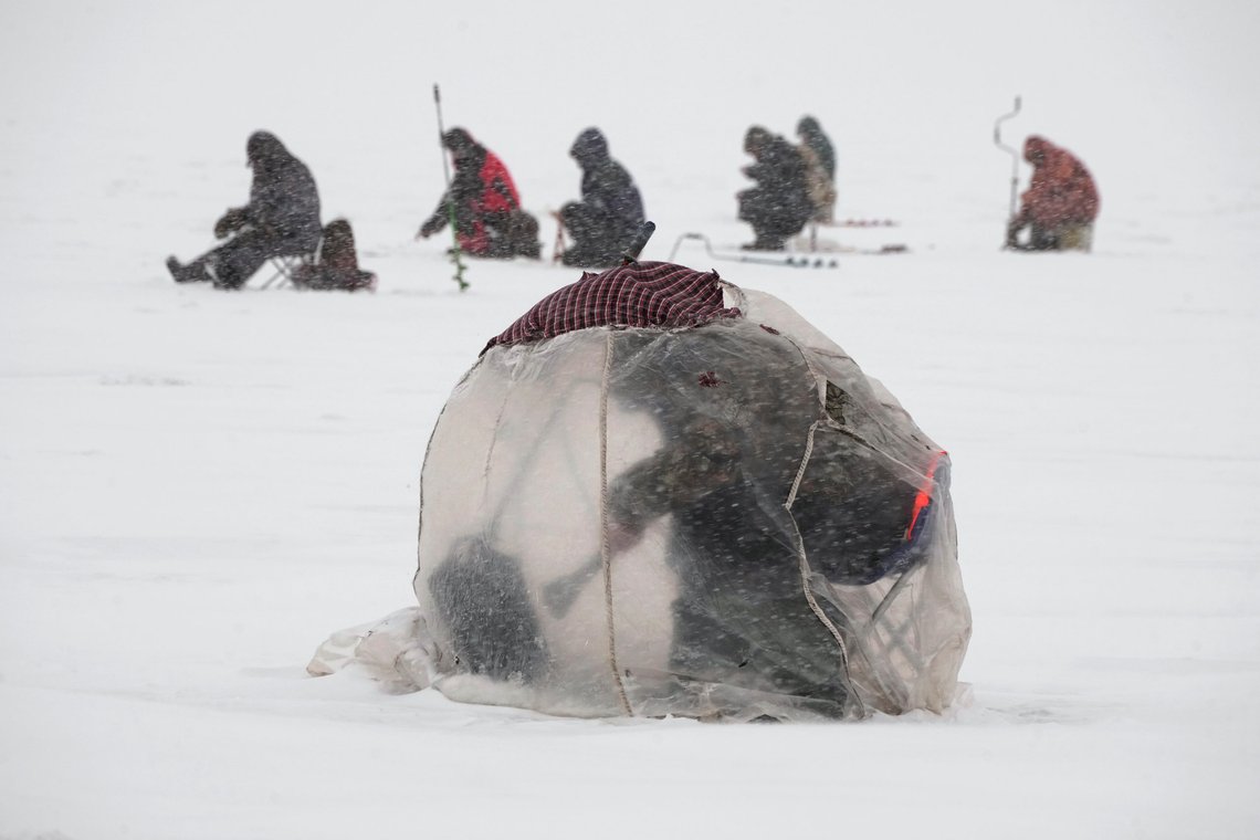 A man fishes on the ice of the Gulf of Finland sitting in a plastic tent protecting himself from the wind during a snowfall in St. Petersburg, Russia, Wednesday, Feb. 14, 2024. The temperatures in St.Petersburg is -10 Celsius (14 Fahrenheit). (AP Photo/Dmitri Lovetsky) A man fishes on the ice of the Gulf of Finland sitting in a plastic tent protecting himself from the wind during a snowfall in St. Petersburg, Russia, Wednesday, Feb. 14, 2024. The temperatures in St.Petersburg is -10 Celsius (14 Fahrenheit). (AP Photo/Dmitri Lovetsky)