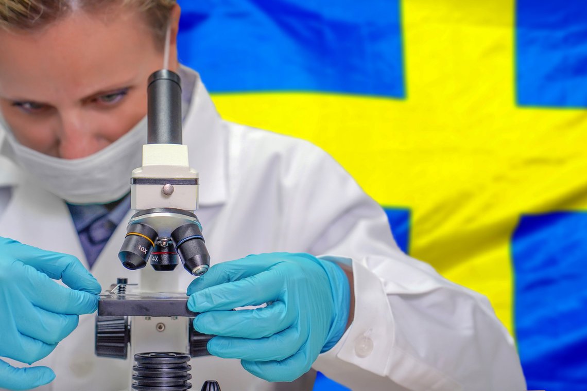 Female biochemist looking through a microscope against Sweden flag background. Photo: Shutterstock by lunopark, United States. Female biochemist looking through a microscope against Sweden flag background. Photo: Shutterstock by lunopark, United States.