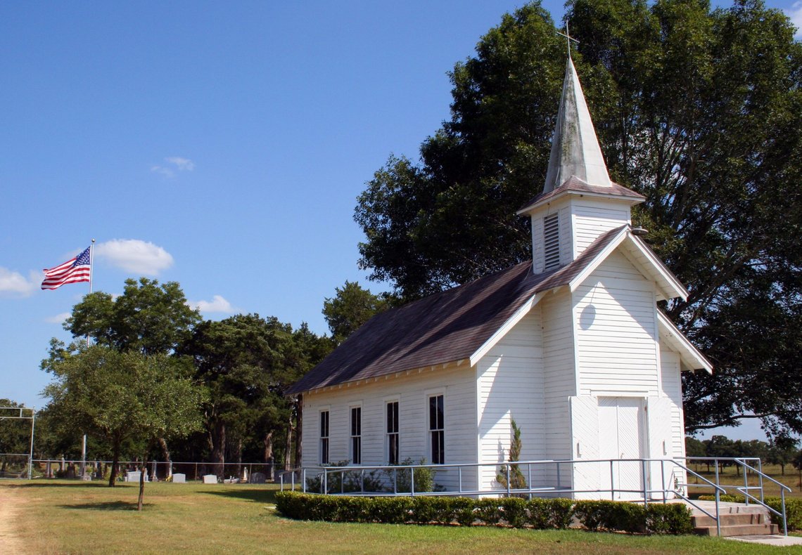 A small rural church in Texas. There is a cemetary and a large oak tree behind the church. Photo: Shutterstock by Brandon Seidel. A small rural church in Texas. There is a cemetary and a large oak tree behind the church. Photo: Shutterstock by Brandon Seidel.