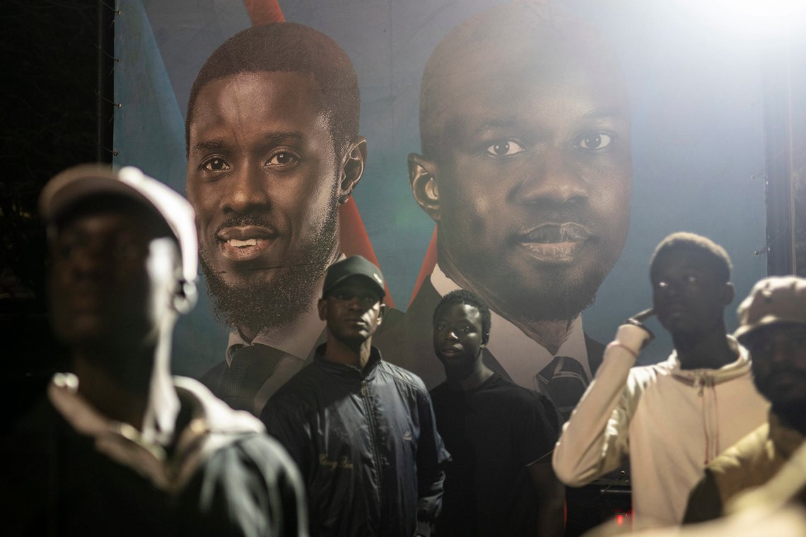 Tilhengere av presidentkandidat Bassirou Diomaye Faye (bak t.v.) og opposisjonsleder Ousmane Sonko, samlet utenfor kampanjehovedkvarteret i hovedstaden Dakar i Senegal etter presidentvalget søndag 24. mars. (Foto: AP/Mosa'ab Elshamy) Bassirou Diomaye Faye og Ousmane Sonko