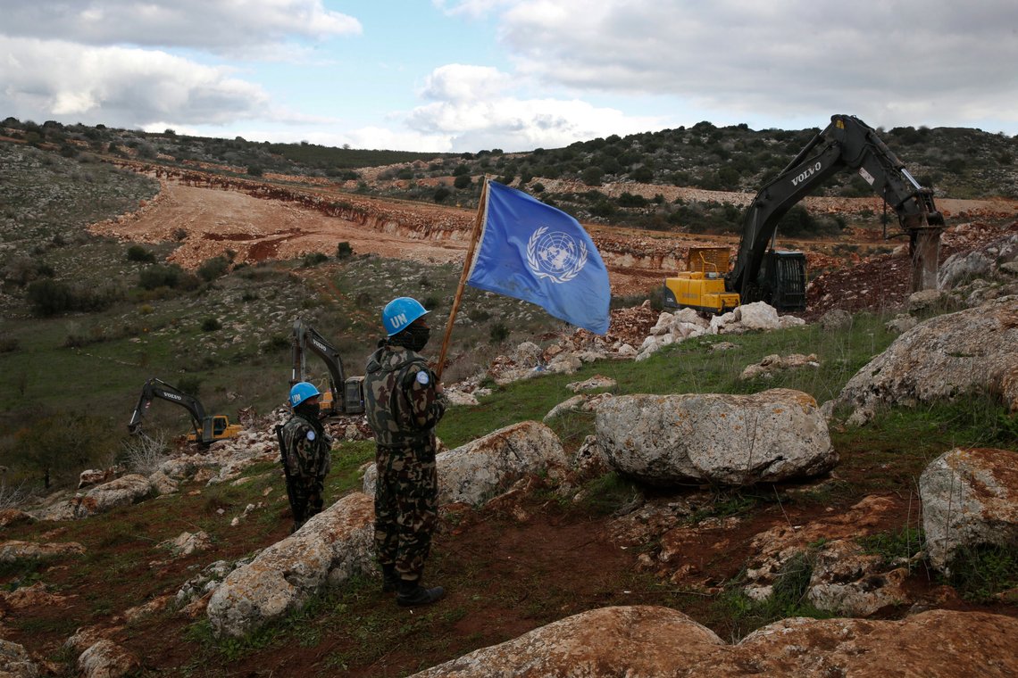 FILE - UN peacekeepers hold their flag, as they observe Israeli excavators attempt to destroy tunnels built by Hezbollah, near the southern Lebanese-Israeli border village of Mays al-Jabal, Lebanon on Dec. 13, 2019. Four United Nations military observers were wounded Saturday while patrolling along the southern Lebanese border after a shell exploded near them, the U.N. peacekeeping mission in southern Lebanon said. The military observers of the United Nations Truce Supervision Organization support the U.N. peacekeeping mission in southern Lebanon, UNIFIL. (AP Photo/Hussein Malla, File) FILE - UN peacekeepers hold their flag, as they observe Israeli excavators attempt to destroy tunnels built by Hezbollah, near the southern Lebanese-Israeli border village of Mays al-Jabal, Lebanon on Dec. 13, 2019. Four United Nations military observers were wounded Saturday while patrolling along the southern Lebanese border after a shell exploded near them, the U.N. peacekeeping mission in southern Lebanon said. The military observers of the United Nations Truce Supervision Organization support the U.N. peacekeeping mission in southern Lebanon, UNIFIL. (AP Photo/Hussein Malla, File)