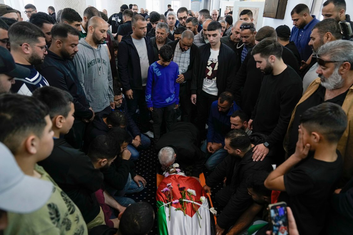 Palestinians gather next to the body of Omar Hamed during his funeral at the village of Beitin, near the West Bank city of Ramallah in the occupied West Bank, Sunday, April 14, 2024. Israeli settlers in the occupied West Bank went on the largest rampage against Palestinians there since the war in Gaza began, as Israel's army said Saturday the body of a missing Israeli teen was found after he was killed in a "terrorist attack." Witnesses said settlers assaulted a number of communities. (AP Photo/Majdi Mohammed) Palestinians gather next to the body of Omar Hamed during his funeral at the village of Beitin, near the West Bank city of Ramallah in the occupied West Bank, Sunday, April 14, 2024. Israeli settlers in the occupied West Bank went on the largest rampage against Palestinians there since the war in Gaza began, as Israel's army said Saturday the body of a missing Israeli teen was found after he was killed in a "terrorist attack." Witnesses said settlers assaulted a number of communities. (AP Photo/Majdi Mohammed)