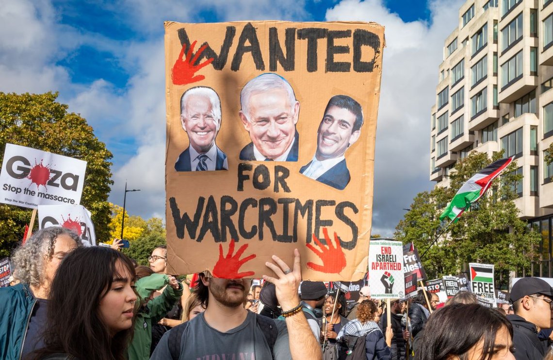 London, Storbritannia - 21. oktober 2023: En pro-palestinsk demonstrant holder en plakat som anklager Biden, Sunak og Netanyahu for krigsforbrytelser under en demonstrasjon mot Israels angrep på Gaza i London sentrum, Storbritannia. Foto: Shutterstock av Andy Soloman, Storbritannia. London, Storbritannia - 21. oktober 2023: En pro-palestinsk demonstrant holder en plakat som anklager Biden, Sunak og Netanyahu for krigsforbrytelser under en demonstrasjon mot Israels angrep på Gaza i London sentrum, Storbritannia. Foto: Shutterstock av Andy Soloman, Storbritannia.
