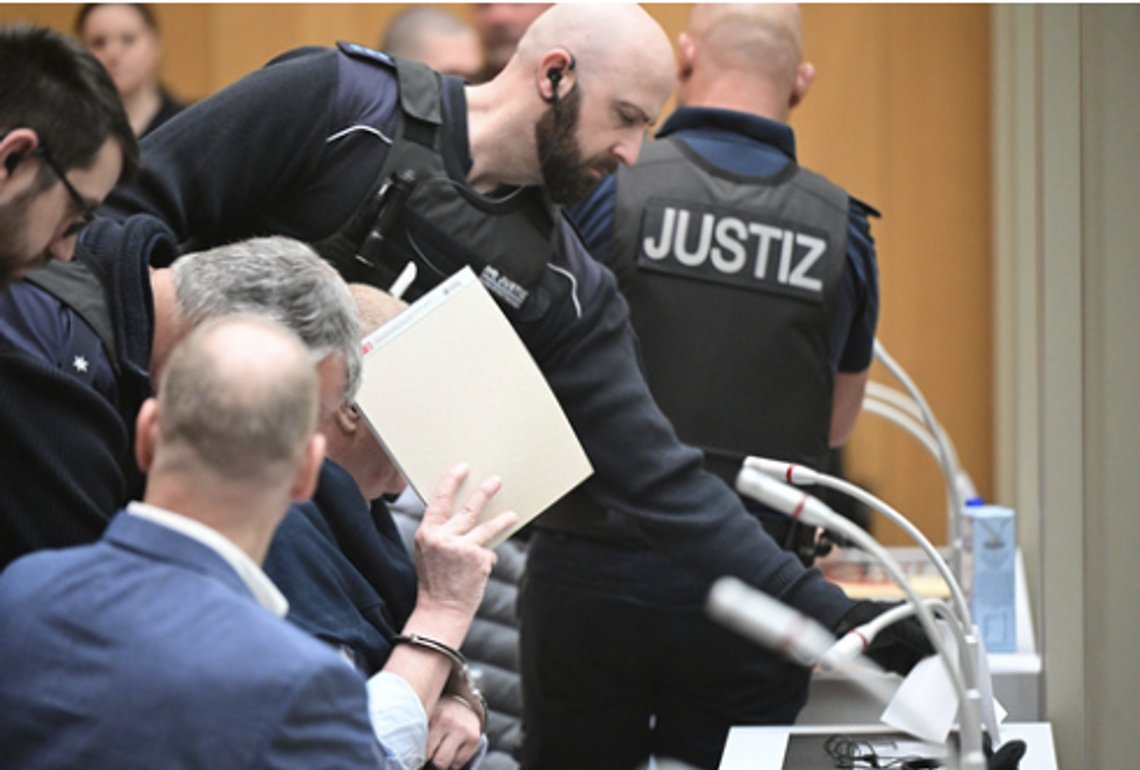 En tiltalt mann ledes inn i lokalet i Stuttgart. Foto: Bernd Weisbrod/dpa via AP/NTB En tiltalt mann ledes inn i lokalet i Stuttgart. Foto: Bernd Weisbrod/dpa via AP/NTB