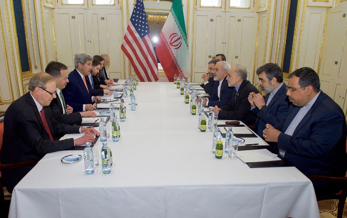 USAs utenriksminister John Kerry, Irans utenriksminister Javad Zarif og deres respektive rådgivere sitter overfor hverandre 16. januar 2015 på Palais Coburg Hotel i Wien, Østerrike, før et møte om implementeringen av Joint Comprehensive Plan of Action, som beskriver Irans atomprogram. Foto: Wikimedia Commons. U.S. Department of State. USAs utenriksminister John Kerry, Irans utenriksminister Javad Zarif og deres respektive rådgivere sitter overfor hverandre 16. januar 2015 på Palais Coburg Hotel i Wien, Østerrike, før et møte om implementeringen av Joint Comprehensive Plan of Action, som beskriver Irans atomprogram. Foto: Wikimedia Commons. U.S. Department of State.