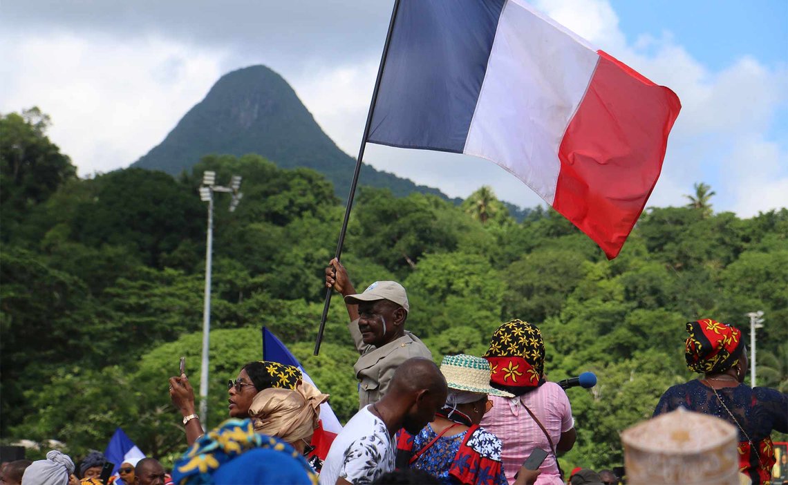 Tilhengere av politiaksjonen «Wuambushu» på Mayotte i fjor, med formål å sende illegale migranter hjem, har samlet seg på en fotballbane i Chirongui. Operasjonen ble en fiasko og førte til at volden økte, ifølge lokalbefolkningen. (Foto: Gregoire Merot/AP Photo.) Tilhengere av politiaksjonen «Wuambushu» på Mayotte i fjor, med formål å sende illegale migranter hjem, har samlet seg på en fotballbane i Chirongui. Operasjonen ble en fiasko og førte til at volden økte, ifølge lokalbefolkningen. (Foto: Gregoire Merot/AP Photo.)