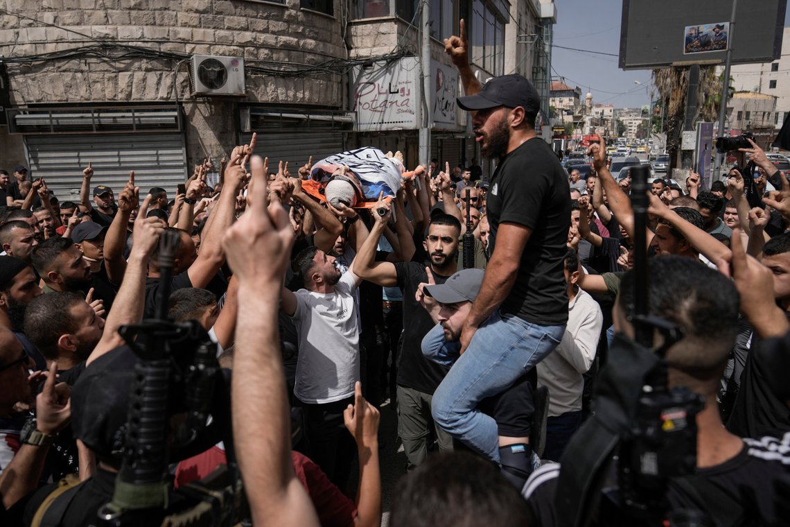 Mourners, some armed, carry the body of Islam Khamaiseh draped in the Islamic Jihad militant group flag during his funeral in the West Bank Jenin refugee camp, Saturday, May 18, 2024. The Israeli military says Khamaiseh, killed by an airstrike in the West Bank on Friday, was responsible for two shooting attacks on civilians, including one in 2023 that killed an Israeli man nearby a West Bank settlement. The militant group Islamic Jihad said that Khamaiseh was a leader of the Jenin Brigade. Palestinian health officials reported that 8 people had been injured in the strike. (AP Photo/Majdi Mohammed) Mourners, some armed, carry the body of Islam Khamaiseh draped in the Islamic Jihad militant group flag during his funeral in the West Bank Jenin refugee camp, Saturday, May 18, 2024. The Israeli military says Khamaiseh, killed by an airstrike in the West Bank on Friday, was responsible for two shooting attacks on civilians, including one in 2023 that killed an Israeli man nearby a West Bank settlement. The militant group Islamic Jihad said that Khamaiseh was a leader of the Jenin Brigade. Palestinian health officials reported that 8 people had been injured in the strike. (AP Photo/Majdi Mohammed)