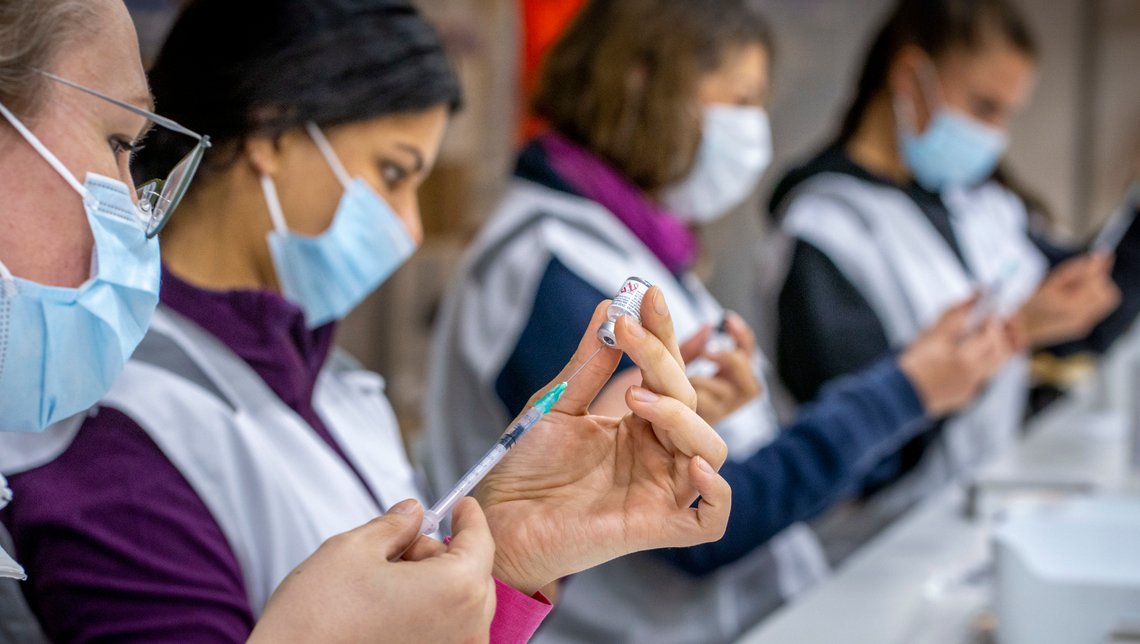Bilde fra 2021, sykepleiere fra Bærum kommune fyller sprøyter med Pfizer-vaksine mot koronavirus på vaksinesenteret på Rud. Foto: Heiko Junge / NTB. Bilde fra 2021, sykepleiere fra Bærum kommune fyller sprøyter med Pfizer-vaksine mot koronavirus på vaksinesenteret på Rud. Foto: Heiko Junge / NTB.