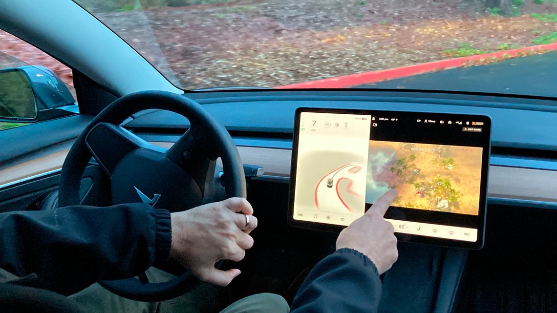 FILE - Vince Patton, a new Tesla owner, demonstrates on Dec. 8, 2021, on a closed course in Portland, Ore., how he can play video games on the vehicle's console while driving. The U.S. has opened a formal investigation into a report that Tesla vehicles allow people to play video games on a center touch screen while they are driving. (AP Photo/Gillian Flaccus, File) FILE - Vince Patton, a new Tesla owner, demonstrates on Dec. 8, 2021, on a closed course in Portland, Ore., how he can play video games on the vehicle's console while driving. The U.S. has opened a formal investigation into a report that Tesla vehicles allow people to play video games on a center touch screen while they are driving. (AP Photo/Gillian Flaccus, File)