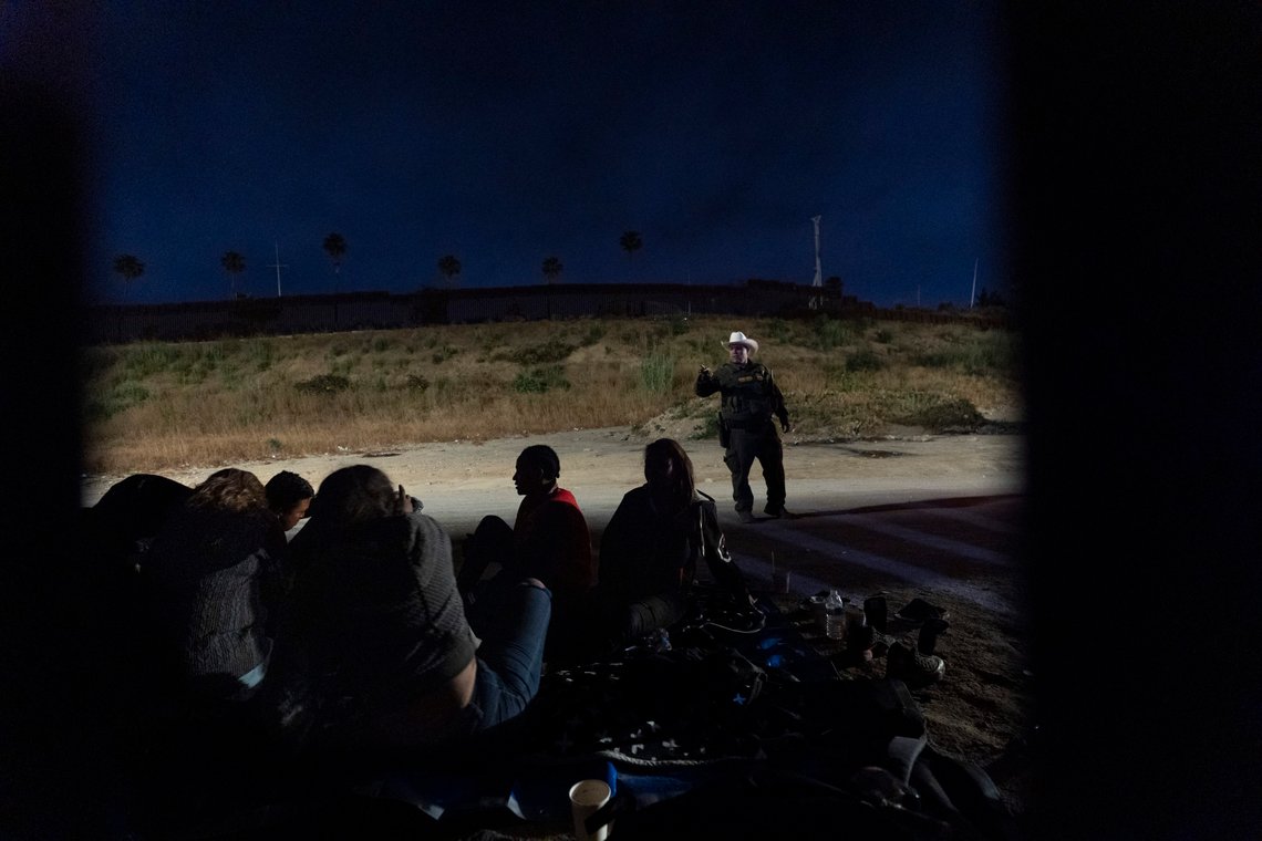 A Border Patrol agent, standing, asks if anyone needs medical attention as he speaks with migrants seeking asylum, waiting to be processed between two border walls, Tuesday, June 4, 2024, in San Diego. President Joe Biden on Tuesday unveiled plans to enact immediate significant restrictions on migrants seeking asylum at the U.S.-Mexico border as the White House tries to neutralize immigration as a political liability ahead of the November elections. (AP Photo/Gregory Bull) A Border Patrol agent, standing, asks if anyone needs medical attention as he speaks with migrants seeking asylum, waiting to be processed between two border walls, Tuesday, June 4, 2024, in San Diego. President Joe Biden on Tuesday unveiled plans to enact immediate significant restrictions on migrants seeking asylum at the U.S.-Mexico border as the White House tries to neutralize immigration as a political liability ahead of the November elections. (AP Photo/Gregory Bull)