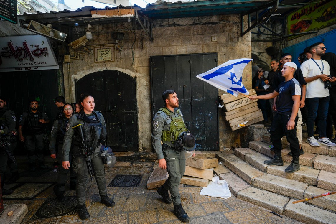 Israeli border police officers look at an Israeli waves a national flag during a march marking Jerusalem Day, in Jerusalem's Old City, Wednesday, June 5, 2024. (AP Photo/Ohad Zwigenberg) Israeli border police officers look at an Israeli waves a national flag during a march marking Jerusalem Day, in Jerusalem's Old City, Wednesday, June 5, 2024. (AP Photo/Ohad Zwigenberg)