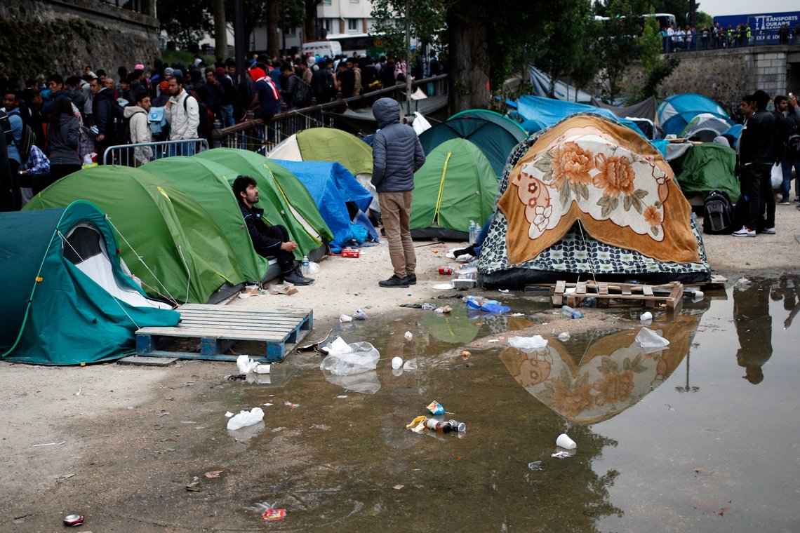 Migrants wait to leave during a clearing out of a makeshift migrant camp along side of the canal Saint Martin, in central Paris, France, Monday, June 4, 2018. French police have evacuated around 500 migrants, mostly Afghans but some Africans from a makeshift tent encampment. (AP Photo/Francois Mori) Migrants wait to leave during a clearing out of a makeshift migrant camp along side of the canal Saint Martin, in central Paris, France, Monday, June 4, 2018. French police have evacuated around 500 migrants, mostly Afghans but some Africans from a makeshift tent encampment. (AP Photo/Francois Mori)