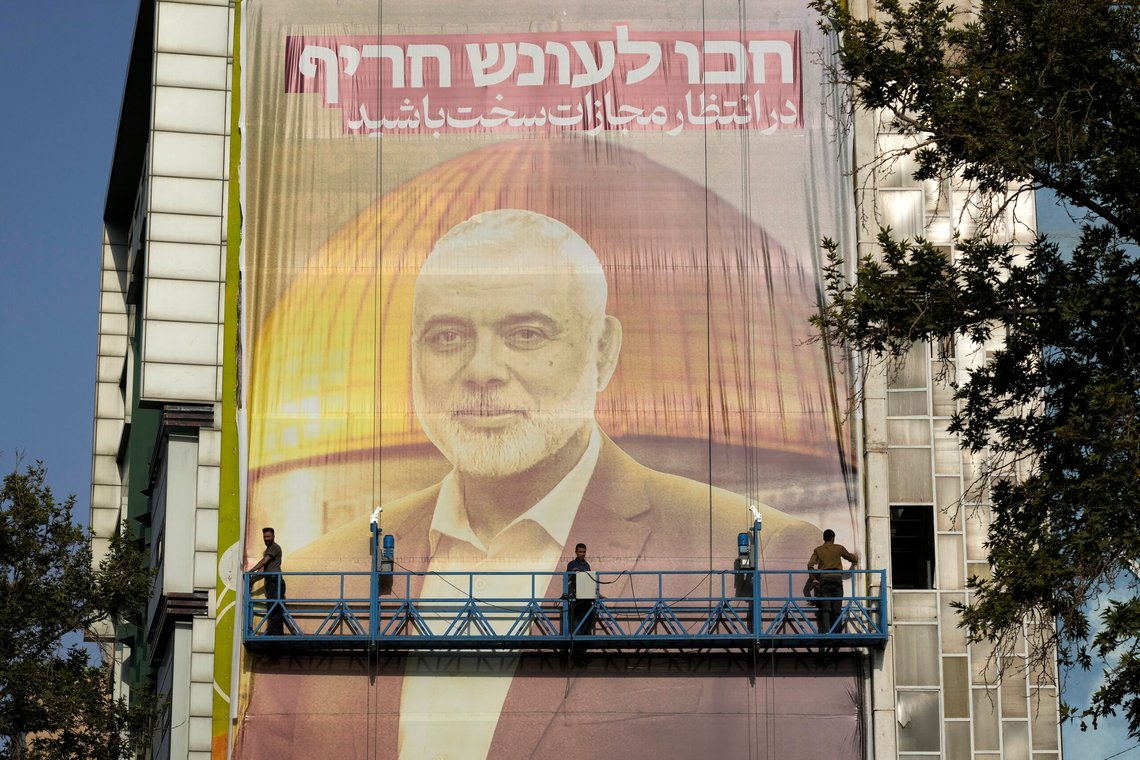 Iranian workers install a huge banner on a wall showing a portrait of Hamas leader Ismail Haniyeh and the Dome of Rock Mosque at the Al-Aqsa Mosque compound of Jerusalem with a sign which reads in Farsi and Hebrew: "Wait for severe punishment," at Felestin (Palestine) Sq. in Tehran, Iran, Wednesday, July 31, 2024. Haniyeh was assassinated in Tehran, Iran's paramilitary Revolutionary Guard said early Wednesday. (AP Photo/Vahid Salemi) Iranian workers install a huge banner on a wall showing a portrait of Hamas leader Ismail Haniyeh and the Dome of Rock Mosque at the Al-Aqsa Mosque compound of Jerusalem with a sign which reads in Farsi and Hebrew: "Wait for severe punishment," at Felestin (Palestine) Sq. in Tehran, Iran, Wednesday, July 31, 2024. Haniyeh was assassinated in Tehran, Iran's paramilitary Revolutionary Guard said early Wednesday. (AP Photo/Vahid Salemi)