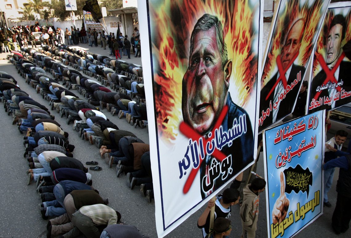Militants from the Islamic Jihad group pray as demonstrators hold large pictures of U.S. President George W. Bush, left, reading "The biggest devil", acting Israeli Prime Minister Ehud Olmert, center, reading "The Zionist Olmert", and Danish Prime Minister Anders Fogh Rasmussen, right, reading "Shame on you, loser" during a protest in Gaza city Tuesday Jan. 31, 2006. About 5,000 members of the militant Islamic Jihad group, including several gunmen, marched in Gaza City on Tuesday demanding Denmark apologize for a caricature published in a local newspaper they said mocked the Muslim prophet Muhammad. Poster on bottom reads in Arabic "The Prophet is our master". (AP Photo/Emilio Morenatti) Militants from the Islamic Jihad group pray as demonstrators hold large pictures of U.S. President George W. Bush, left, reading "The biggest devil", acting Israeli Prime Minister Ehud Olmert, center, reading "The Zionist Olmert", and Danish Prime Minister Anders Fogh Rasmussen, right, reading "Shame on you, loser" during a protest in Gaza city Tuesday Jan. 31, 2006. About 5,000 members of the militant Islamic Jihad group, including several gunmen, marched in Gaza City on Tuesday demanding Denmark apologize for a caricature published in a local newspaper they said mocked the Muslim prophet Muhammad. Poster on bottom reads in Arabic "The Prophet is our master". (AP Photo/Emilio Morenatti)