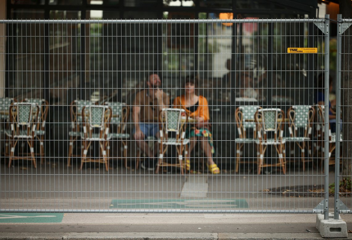 Et par sitter på en kaféterrasse bak sikkerhetssperringene ved sommer-OL 2024 i Paris, Frankrike. Foto: Thomas Padilla, AP-NTB. Et par sitter på en kaféterrasse bak sikkerhetssperringene ved sommer-OL 2024 i Paris, Frankrike. Foto: Thomas Padilla, AP-NTB.