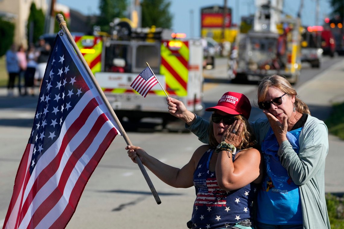 Merri Cambo, left, of Saxonburg, Pa., and her friend, Jane Wesolosky, of Buffalo, Pa., react as the funeral procession for Corey Comperatore passes by, Friday, July 19, 2024, in Sarver, Pa. Comperatore, a former fire chief, was shot and killed while attending a weekend rally for former President Donald Trump. (AP Photo/Matt Slocum) Merri Cambo, left, of Saxonburg, Pa., and her friend, Jane Wesolosky, of Buffalo, Pa., react as the funeral procession for Corey Comperatore passes by, Friday, July 19, 2024, in Sarver, Pa. Comperatore, a former fire chief, was shot and killed while attending a weekend rally for former President Donald Trump. (AP Photo/Matt Slocum)