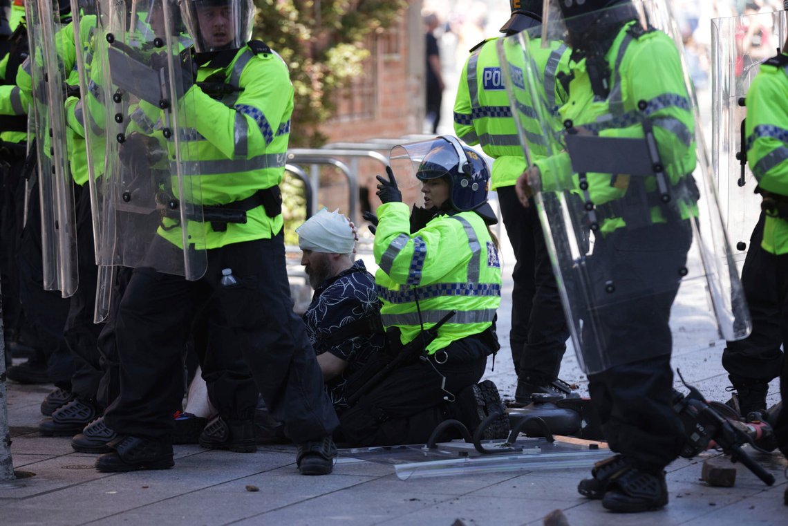 Politi og helsepersonell tar hånd om en skadet person under en protest i Liverpool lørdag. Det meldes om opptøyer i flere britiske byer. Foto: James Speakman / AP / NTB Politi og helsepersonell tar hånd om en skadet person under en protest i Liverpool lørdag. Det meldes om opptøyer i flere britiske byer. Foto: James Speakman / AP / NTB