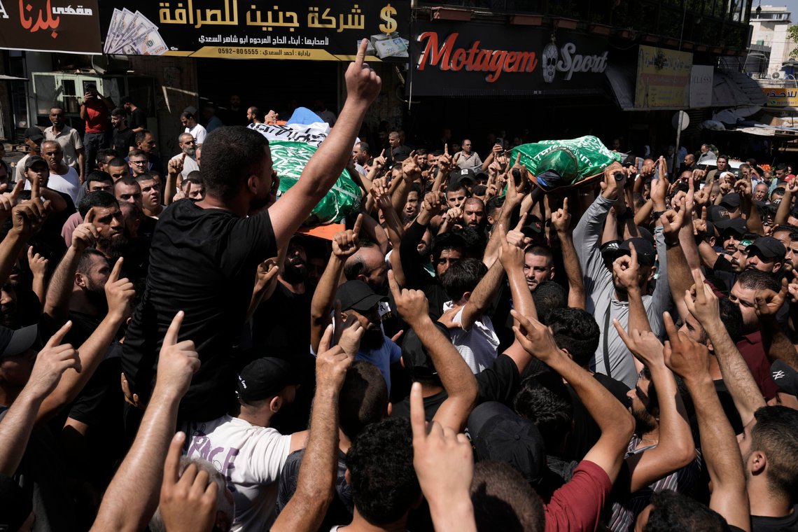 Mourners march during a funeral with the bodies of Palestinians Ahmed Abu Arra from the town of Aqaba, left, and Raafat Dawasa from the town of Silat Al-Harithiya, both draped in the Hamas flag and killed in an Israeli strike in the Jenin refugee camp, in the West Bank city of Jenin, Sunday, Aug. 18, 2024. Israel's military said Saturday it struck a "terrorist cell" in Jenin. The Palestinian health ministry there said two bodies were taken to a government hospital; Hamas claimed the two men as commanders in its military wing. (AP Photo/Majdi Mohammed) Mourners march during a funeral with the bodies of Palestinians Ahmed Abu Arra from the town of Aqaba, left, and Raafat Dawasa from the town of Silat Al-Harithiya, both draped in the Hamas flag and killed in an Israeli strike in the Jenin refugee camp, in the West Bank city of Jenin, Sunday, Aug. 18, 2024. Israel's military said Saturday it struck a "terrorist cell" in Jenin. The Palestinian health ministry there said two bodies were taken to a government hospital; Hamas claimed the two men as commanders in its military wing. (AP Photo/Majdi Mohammed)