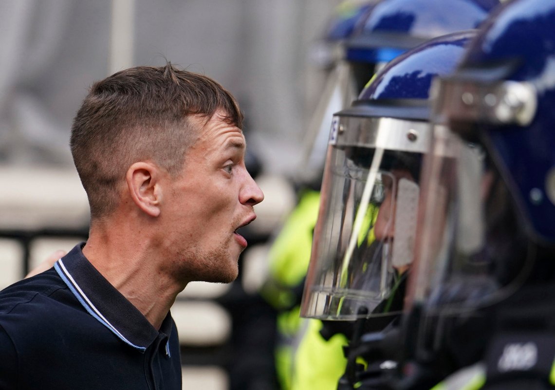 En rasende brite står ansikt til ansikt med opprørspoliti og roper «Enough is Enough». Foto: Jordan Pettitt / PA / AP / NTB En rasende brite står ansikt til ansikt med opprørspoliti og roper «Enough is Enough». Foto: Jordan Pettitt / PA / AP / NTB