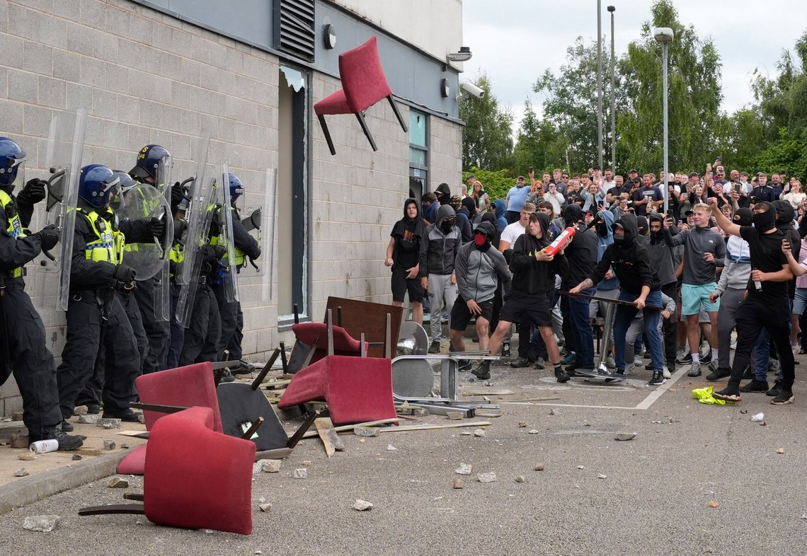 A chair is thrown at police officers as trouble flares during an anti-immigration protest outside the Holiday Inn Express in Rotherham, England, Sunday Aug. 4, 2024. (Danny Lawson/PA via AP) A chair is thrown at police officers as trouble flares during an anti-immigration protest outside the Holiday Inn Express in Rotherham, England, Sunday Aug. 4, 2024. (Danny Lawson/PA via AP)