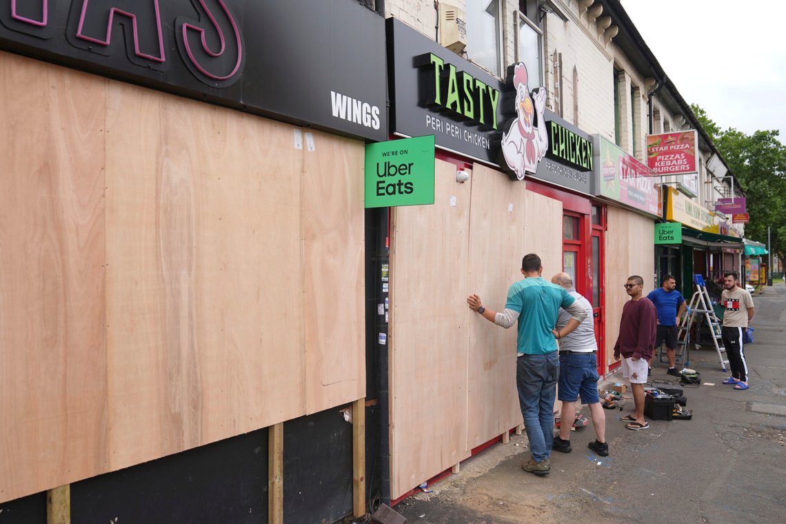 Folk dekker til restauranter og butikkvinduer i Northampton i England i frykt for hærverk i forbindelse med opptøyer i byen. Foto: Joe Giddens / PA / AP / NTB Folk dekker til restauranter og butikkvinduer i Northampton i England i frykt for hærverk i forbindelse med opptøyer i byen. Foto: Joe Giddens / PA / AP / NTB